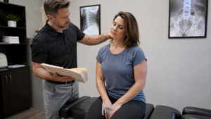 patient discussing neck pain with chiropractor in exam room after auto accident, calm clinical setting